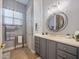 Stylish bathroom featuring a vanity with gray cabinets, a mirror, and attractive lighting at 112 Sevilla Ct, Poinciana, FL 34759