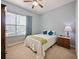 Comfortable bedroom with a bed, carpet flooring, and natural light from a window at 112 Sevilla Ct, Poinciana, FL 34759