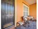 Close-up of the charming screened front porch featuring brick flooring, neutral decor, and a cozy seating area at 112 Sevilla Ct, Poinciana, FL 34759