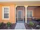 Charming screened front porch featuring brick flooring, neutral decor, and a cozy seating area at 112 Sevilla Ct, Poinciana, FL 34759