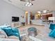 Relaxing living room featuring a sofa, chair, stylish rug, and a view of the adjacent kitchen at 112 Sevilla Ct, Poinciana, FL 34759