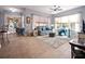 Inviting living room featuring a comfortable grey sofa, ceiling fan, and bright natural light from the windows at 112 Sevilla Ct, Poinciana, FL 34759