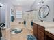 Bright main bathroom featuring double sinks, a soaking tub, and a glass-enclosed shower at 112 Sevilla Ct, Poinciana, FL 34759