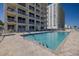 Outdoor pool area with brick-paved pool deck, blue railings, and ocean views at 2071 S Atlantic Ave # 201, Daytona Beach Shores, FL 32118