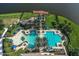 Aerial view of the community pool area, complete with a large pool, lounge chairs, and palm trees at 1128 Kilkenny Ln, Ormond Beach, FL 32174