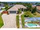 Landscaped home with a brick paved driveway and screened-in pool at 3 Seabridge Dr, Ormond Beach, FL 32176