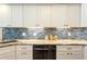 Modern kitchen with granite countertops, white cabinets, and a blue tile backsplash at 3 Seabridge Dr, Ormond Beach, FL 32176