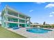 Stunning three-story home with a pool, multiple balconies, and vibrant exterior paint, perfect for coastal living at 4711 S Atlantic Ave, Ponce Inlet, FL 32127