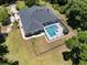 Aerial view of a secluded home featuring a screened pool and a large backyard with secure fencing at 5701 John Anderson Hwy, Flagler Beach, FL 32136