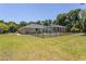 Fenced backyard featuring a screened pool and lush lawn at 5701 John Anderson Hwy, Flagler Beach, FL 32136