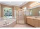 Spacious bathroom with a garden tub, a glass-enclosed shower, and wooden cabinetry at 5701 John Anderson Hwy, Flagler Beach, FL 32136