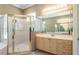 Well-lit bathroom with a glass-enclosed shower, vanity, and large mirror at 5701 John Anderson Hwy, Flagler Beach, FL 32136