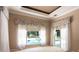 Bedroom with decorative window treatments and a view overlooking the screened-in pool area at 5701 John Anderson Hwy, Flagler Beach, FL 32136