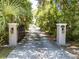 Gated entrance with stone pillars leads to a private driveway and residence at 5701 John Anderson Hwy, Flagler Beach, FL 32136