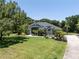Charming home with mature trees, lush lawn, manicured landscaping, and a paved driveway at 5701 John Anderson Hwy, Flagler Beach, FL 32136