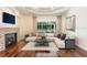 Living room featuring hardwood floors, a fireplace, large windows overlooking the pool, and an L-shaped couch at 5701 John Anderson Hwy, Flagler Beach, FL 32136