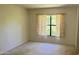 Cozy bedroom featuring a window with curtains and carpeted floors, ready for personalization and comfortable living at 108 Lacosta Ln # 621, Daytona Beach, FL 32114