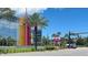 Street view of a commercial area with modern buildings, colorful signage, and lush landscaping along Daytona Blvd at 108 Lacosta Ln # 621, Daytona Beach, FL 32114