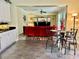 Open-concept living room features a plush red sofa, modern decor, and seamless transition to the kitchen area at 28 Dormer Dr, Ormond Beach, FL 32174