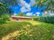 Expansive back yard featuring a lush lawn, mature trees, and a private patio area at 1119 Indigo Rd, Ormond Beach, FL 32174
