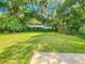 A lush backyard with a well-maintained lawn and mature trees offering ample shade at 1119 Indigo Rd, Ormond Beach, FL 32174