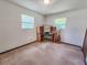 This carpeted bedroom has two windows and includes a built-in shelving unit with an attached desk at 1119 Indigo Rd, Ormond Beach, FL 32174