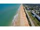 This gorgeous aerial shot showcases a pristine coastline, sandy beaches, and blue ocean waters near hotels and paved roadways at 10 Juniper Dr, Ormond Beach, FL 32176