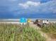 Beach access featuring a sign for Ormond Shores Estates community, a boardwalk, and ocean view at 10 Juniper Dr, Ormond Beach, FL 32176
