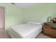A bright bedroom with light green walls and a simple bed frame by the window at 10 Juniper Dr, Ormond Beach, FL 32176