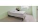 A bright bedroom with light green walls and a simple bed frame by the window at 10 Juniper Dr, Ormond Beach, FL 32176