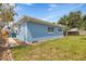 Exterior view of a blue house with white trim and windows, nestled in a well-maintained yard with ample space at 10 Juniper Dr, Ormond Beach, FL 32176