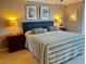 Cozy bedroom with a striped bedspread, blue headboard, matching nightstands, and soft lighting at 64 Ocean Palm S Dr # 64, Flagler Beach, FL 32136