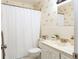 Cozy bathroom featuring neutral tones, seashell wallpaper, shower-tub, and a mirrored vanity at 50 Ocean Palm Villa S, Flagler Beach, FL 32136