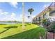 Beautiful view from the manicured lawn to a waterfront condo featuring palms and tropical plants at 50 Ocean Palm Villa S, Flagler Beach, FL 32136