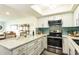 Updated kitchen with stainless steel appliances, white cabinetry, and granite countertops at 50 Ocean Palm Villa S, Flagler Beach, FL 32136