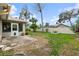 Backyard with grassy area, screened patio, and partial fence at 928 George Hecker Dr, South Daytona, FL 32119
