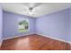Light purple bedroom with wood flooring, window, and ceiling fan at 928 George Hecker Dr, South Daytona, FL 32119