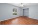 Bedroom with wood flooring, window, and open shelving at 928 George Hecker Dr, South Daytona, FL 32119