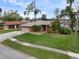 Well-maintained brick home with large front yard, mature landscaping, and attached garage at 928 George Hecker Dr, South Daytona, FL 32119