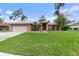 Charming single-story brick home with a lush lawn, mature trees, and attached two-car garage at 928 George Hecker Dr, South Daytona, FL 32119