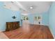 Living room with hardwood floors, light blue walls and access to kitchen at 928 George Hecker Dr, South Daytona, FL 32119
