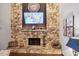 Elegant stone fireplace with decorative mantle, TV, and adjacent artwork at 100 Longspur Ct, Daytona Beach, FL 32119
