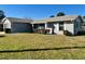 Inviting single-story home with a neatly manicured lawn and classic white shutters, showcasing curb appeal at 305 American Way, Daytona Beach, FL 32119