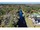 Aerial view of a canal-front home with mature trees and other houses nearby at 1069 Indigo Rd, Ormond Beach, FL 32174