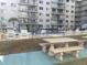 Community pool with surrounding lounge chairs and tables at 2727 N Atlantic Ave # 203, Daytona Beach, FL 32118