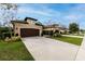 Tan two-story house with brown garage door and landscaping at 3242 Bailey Ann Dr, Ormond Beach, FL 32174