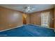 Spacious bedroom with blue carpet, ceiling fan, and access to patio at 640 N Nova Rd # 212, Ormond Beach, FL 32174