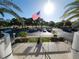 View from balcony with flag showing a parking lot surrounded by tropical landscaping and a view of sunny skies at 935 N Halifax Ave # 602, Daytona Beach, FL 32118