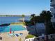 Waterfront pool with lounge chairs, umbrellas, pier, and palm trees offering relaxation and recreation at 935 N Halifax Ave # 602, Daytona Beach, FL 32118