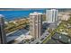 Aerial view showcasing a high-rise building near the water, with tennis courts and parking at 1 Oceans West Blvd # 16A4, Daytona Beach Shores, FL 32118